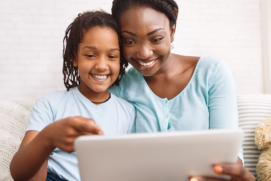 Contact - Mom and Daughter Making a Video Call on a Tablet at Home